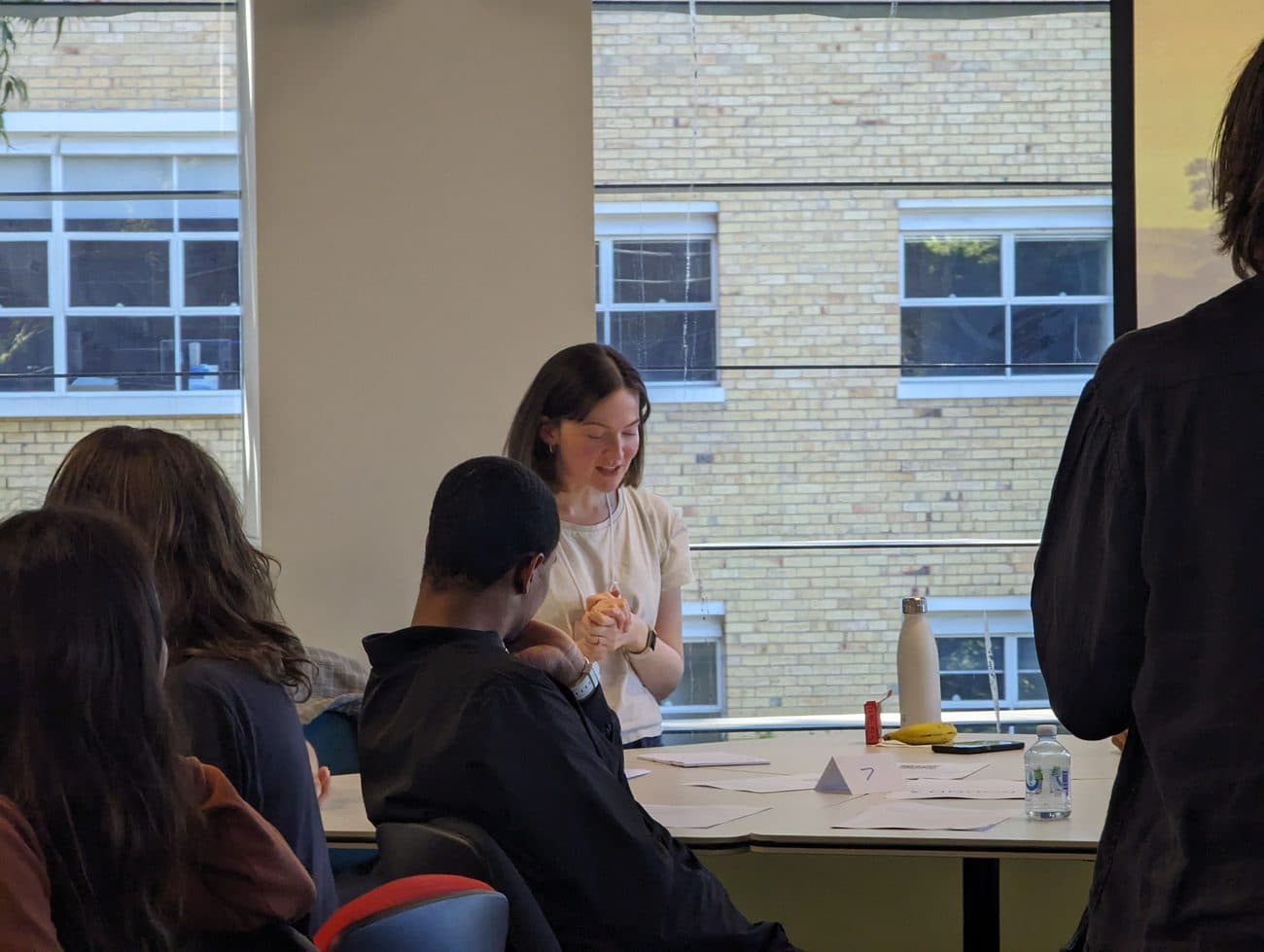 A participant reads her cell's response back to the table during a round of the game.